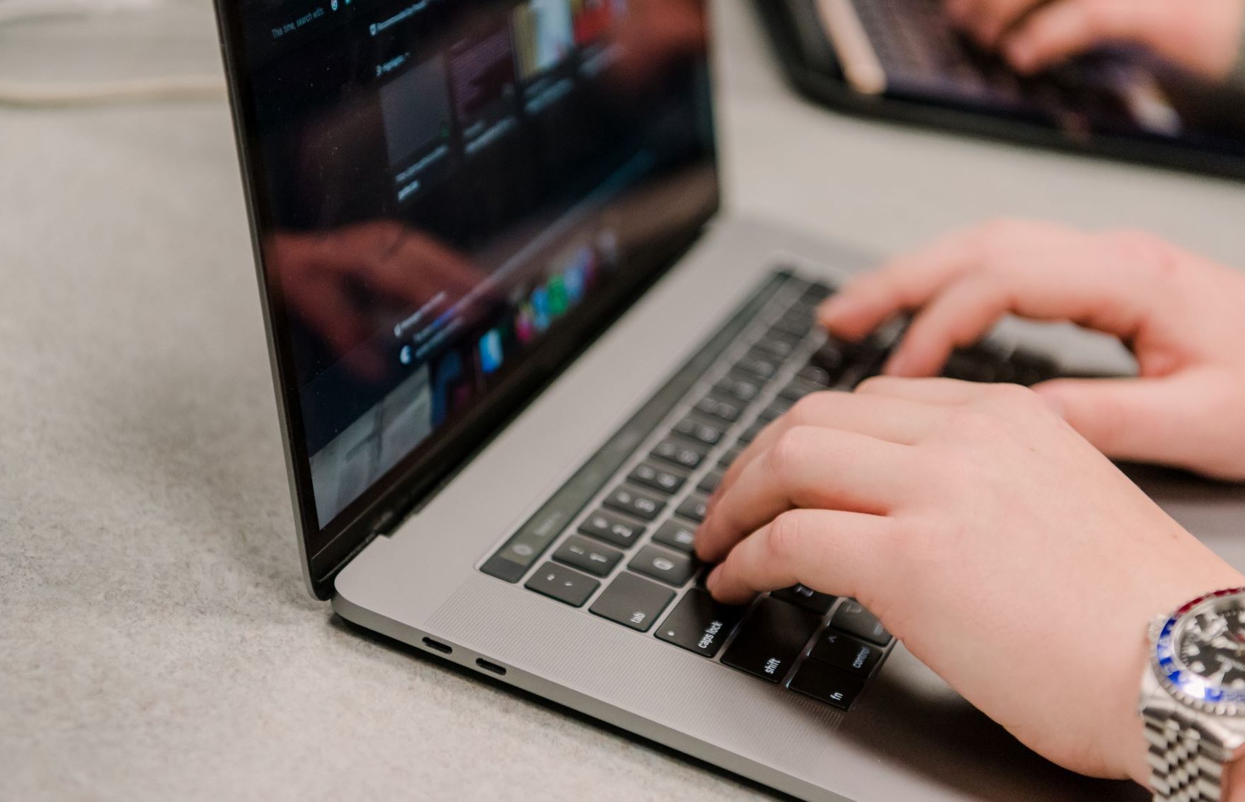 Hands typing on a laptop.