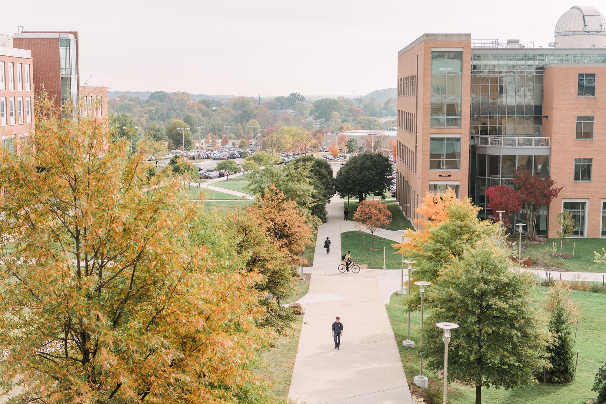 View overlooking campus during the fall season. Students can be seen walking and riding their bike to get around.