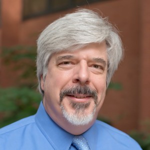 Portrait of a man with gray hair, a mustache, beard, and dress shirt