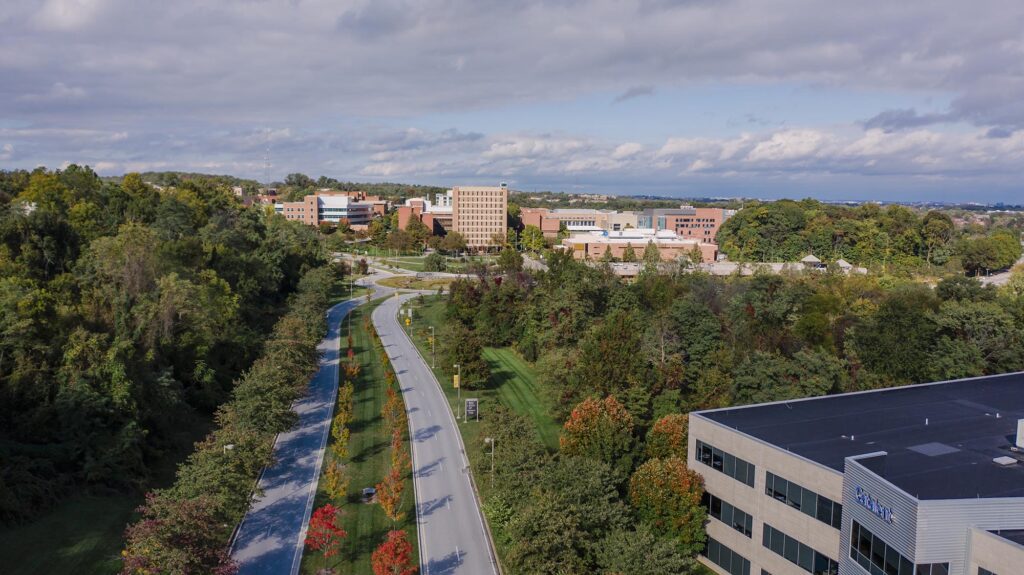 Aerial view of UMBC's campus, featuring a long road.