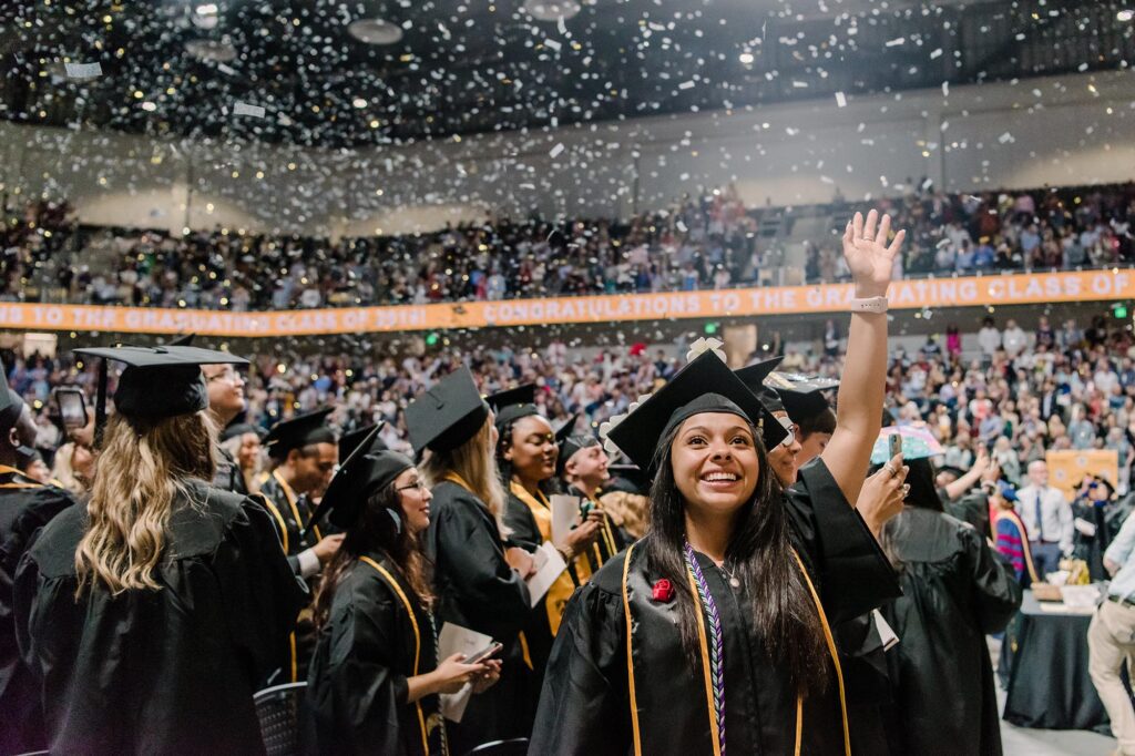 Students cheering at their graduation ceremony.