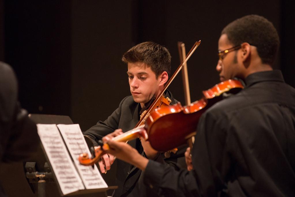 Musicians perform on string instruments against a black background