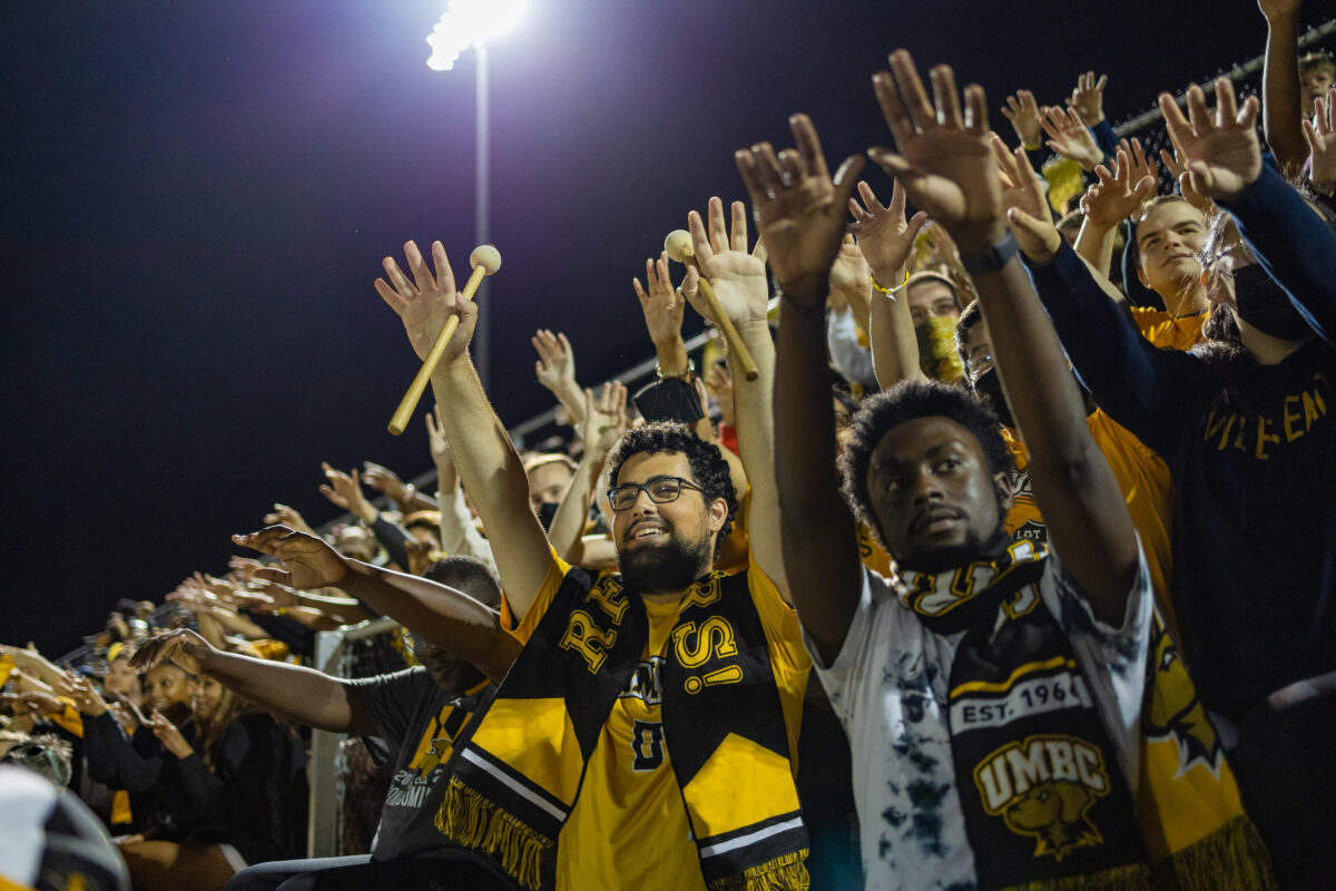 students cheering at a nighttime soccer game