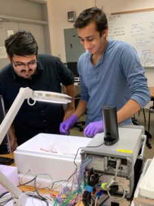 Two students look at equipment in an engineering lab