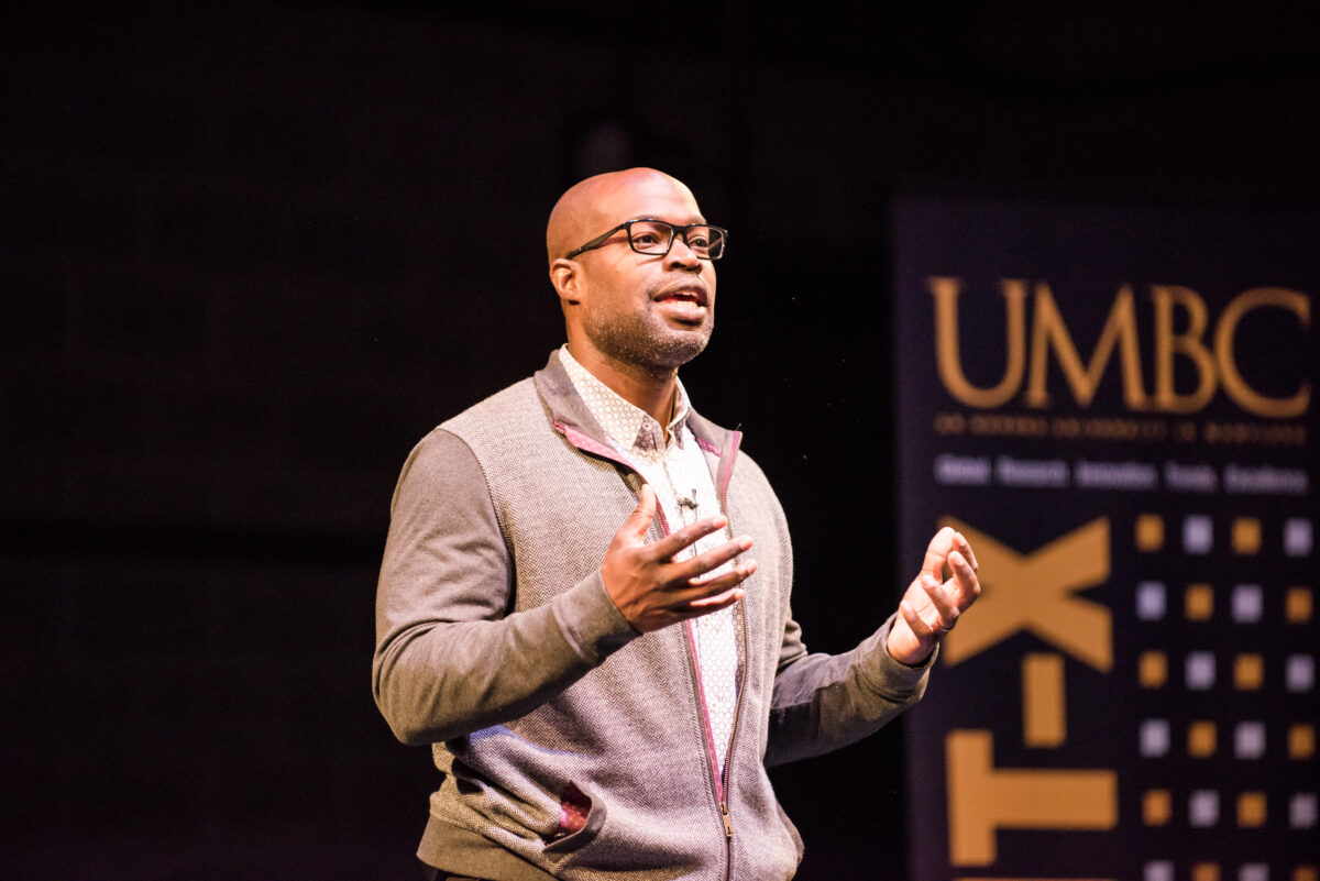 Kafui Dzirasa speaking and gesturing on a black background with a GRIT-X banner