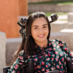a student sits in her wheelchair outside