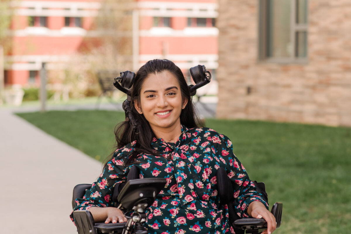 a student sits in her wheelchair outside