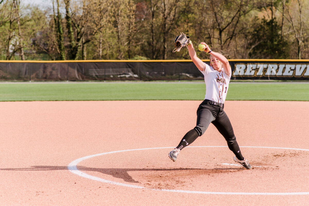 Woman softball pitcher in motion to throw a pitch