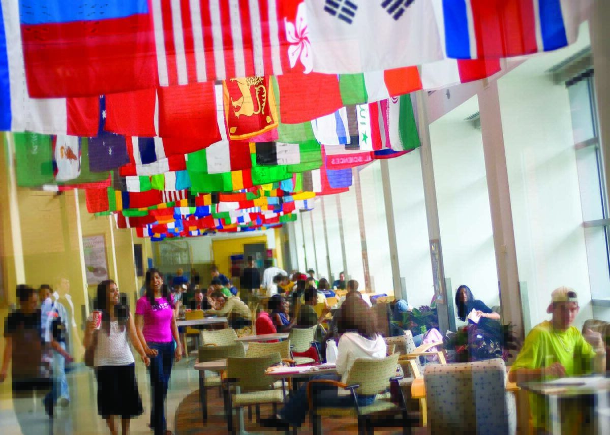 students studying and eating below flags from around the world