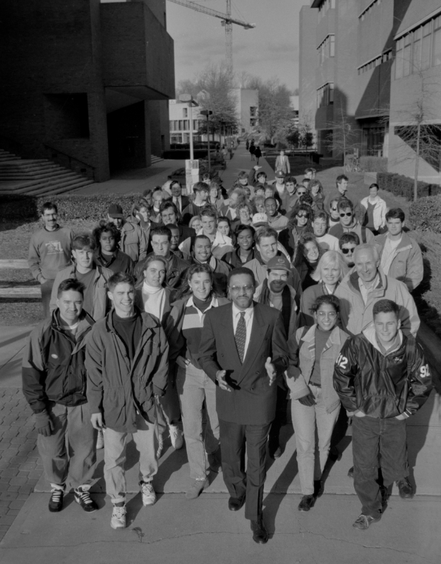 community members gather in a campus walkway behind their university president