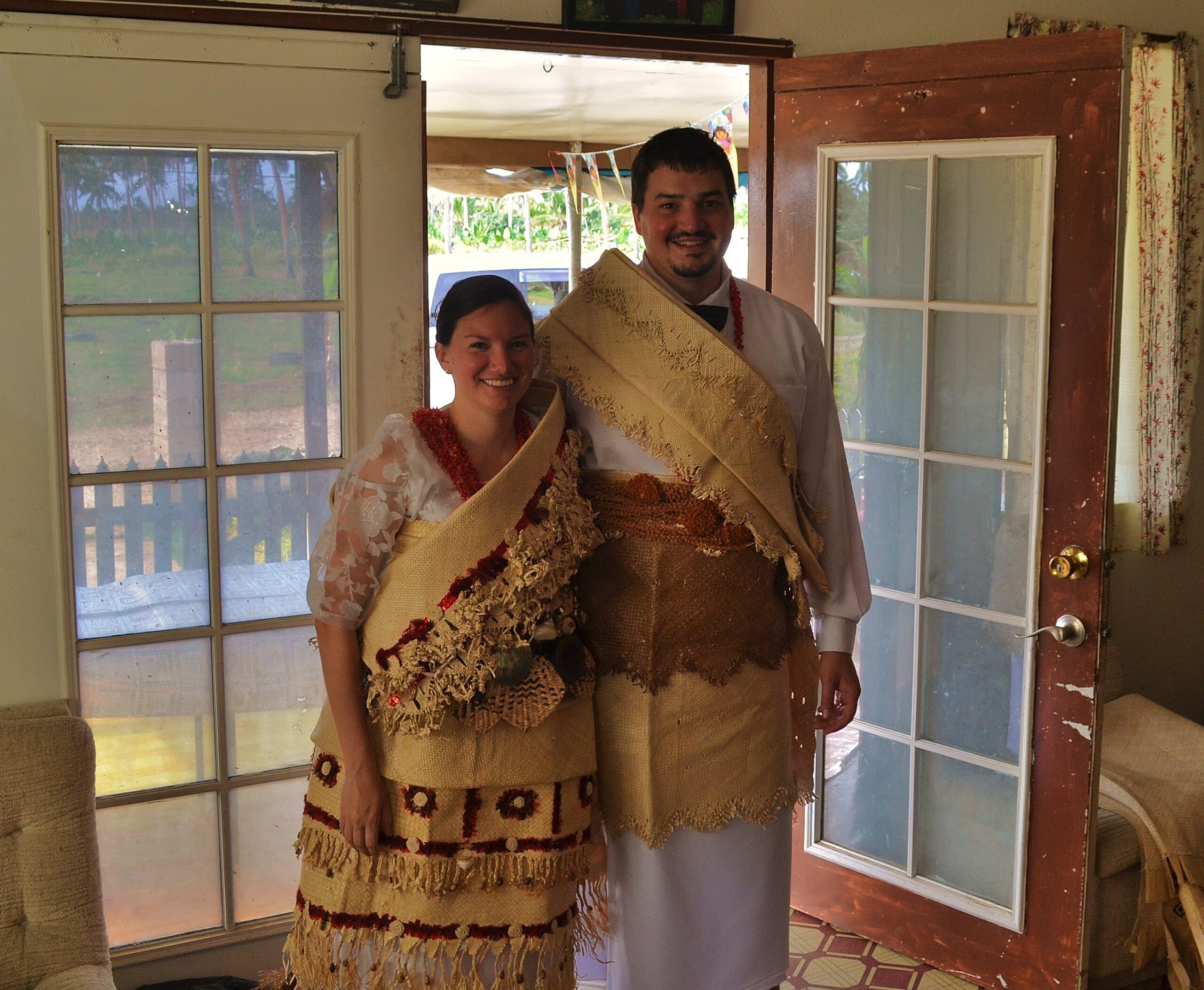 Two people standing side by side wearing traditional Tongan wedding clothes. Peaceworkers.