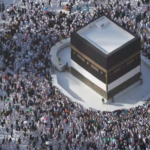Crowds gather at Kaab "the house of God" a large rectangular building with white, brown, and black layers of stone. in Mecca, Saudi Arabia for Hajj,