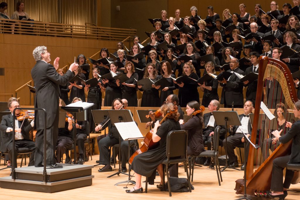 A large chorus performs on stage