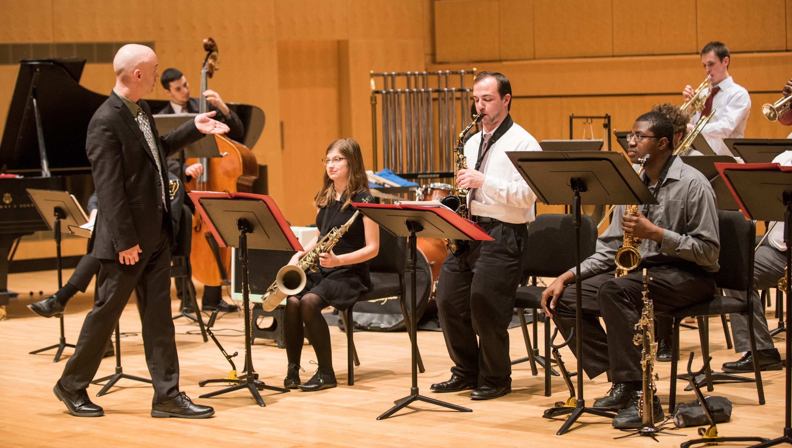 A group of jazz musicians play their instruments on stage