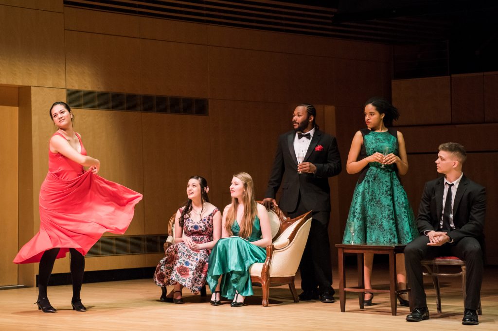 A group of musicians perform an opera scene on stage