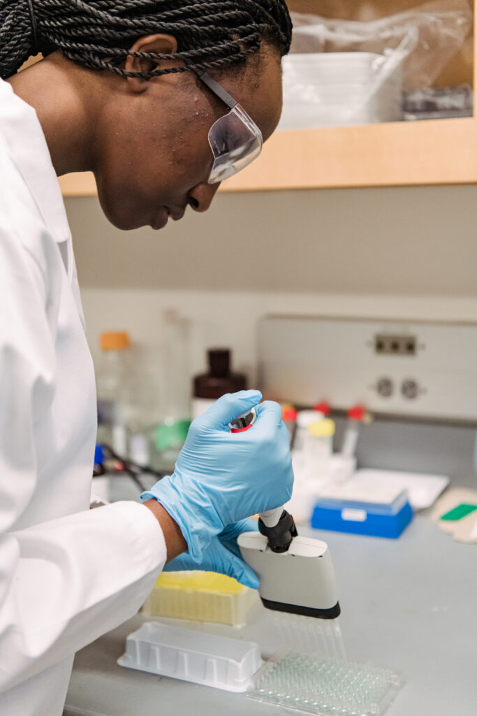 student uses a mass pipetting tool to conduct research