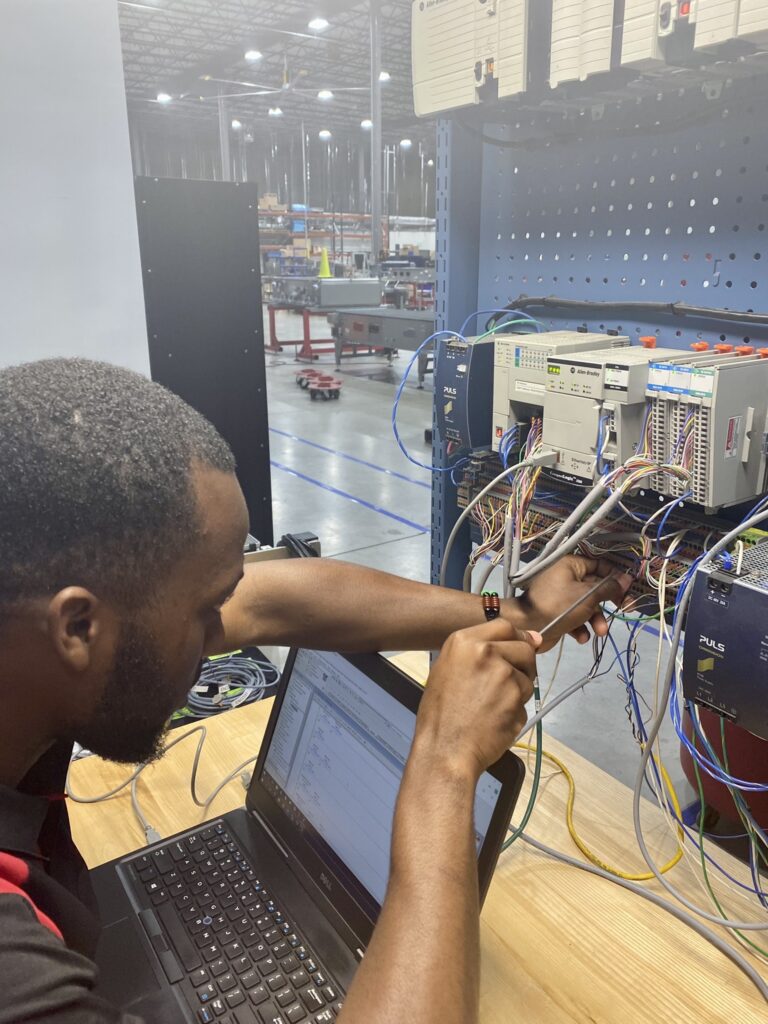 A man works with wires at a desk