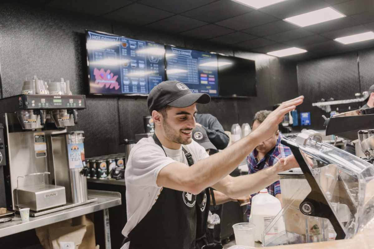 a young man making coffee behind the counter