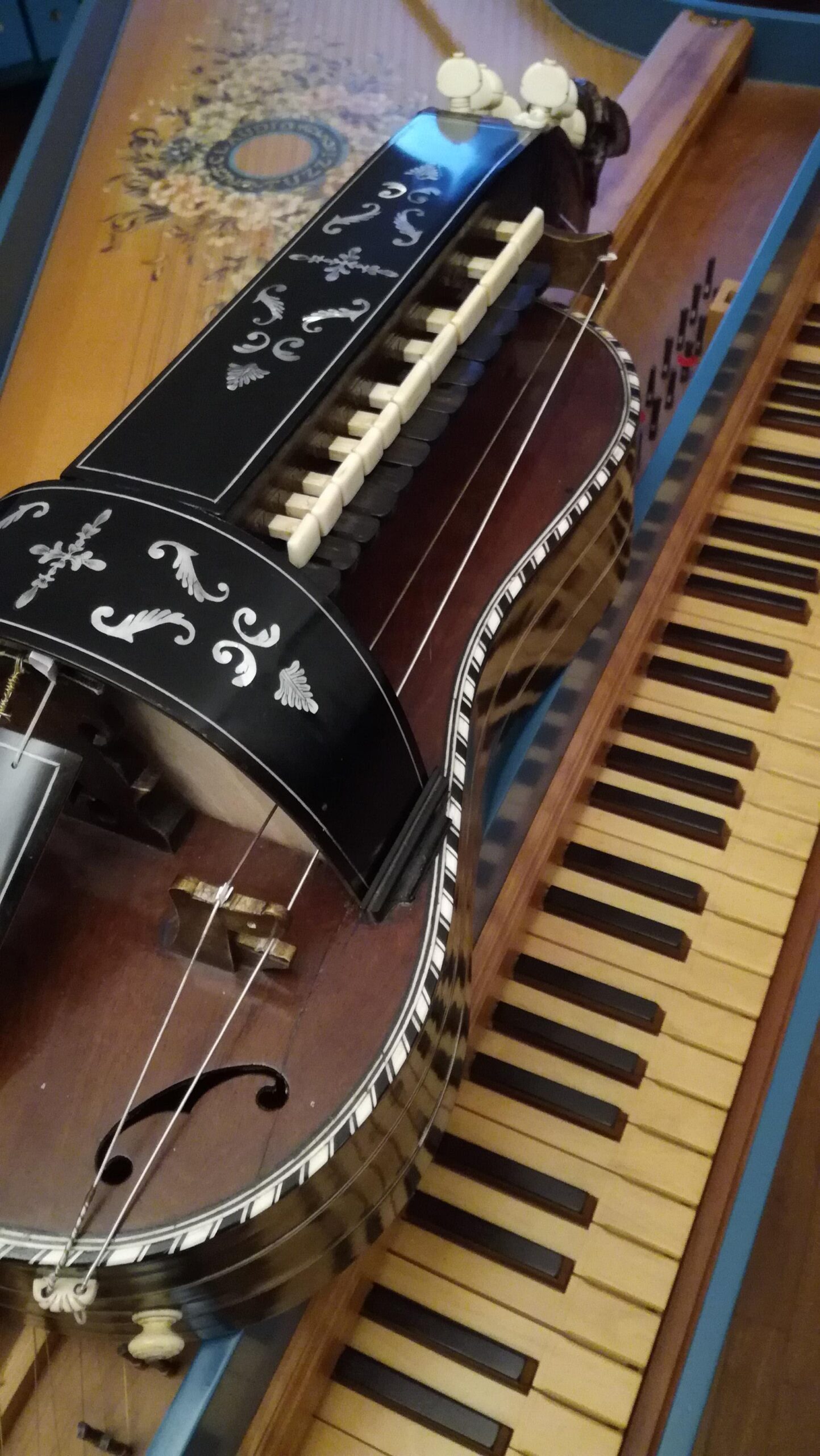 Two musical instruments: a hurdy gurdy and a harpsichord.