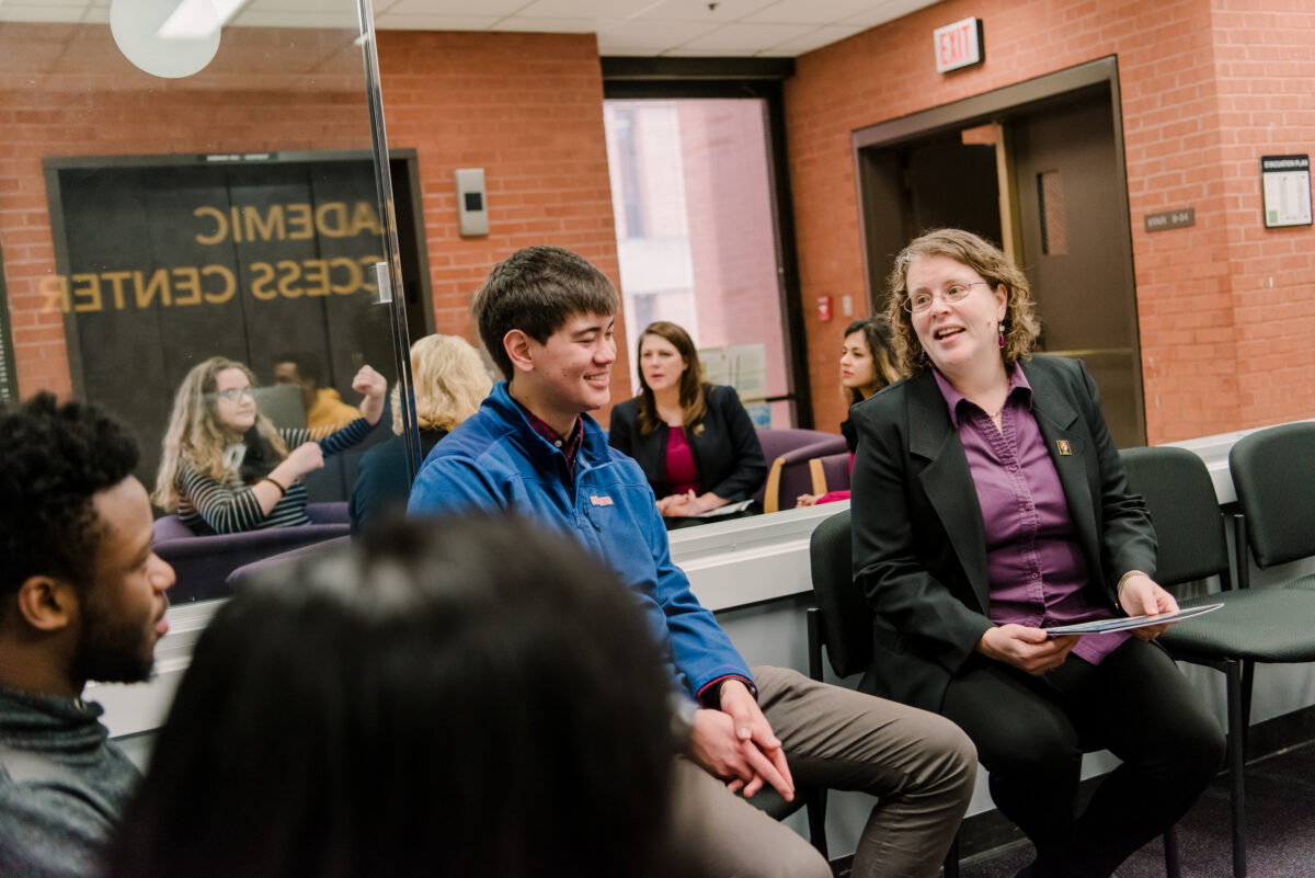 Several people are seated in a room, talking