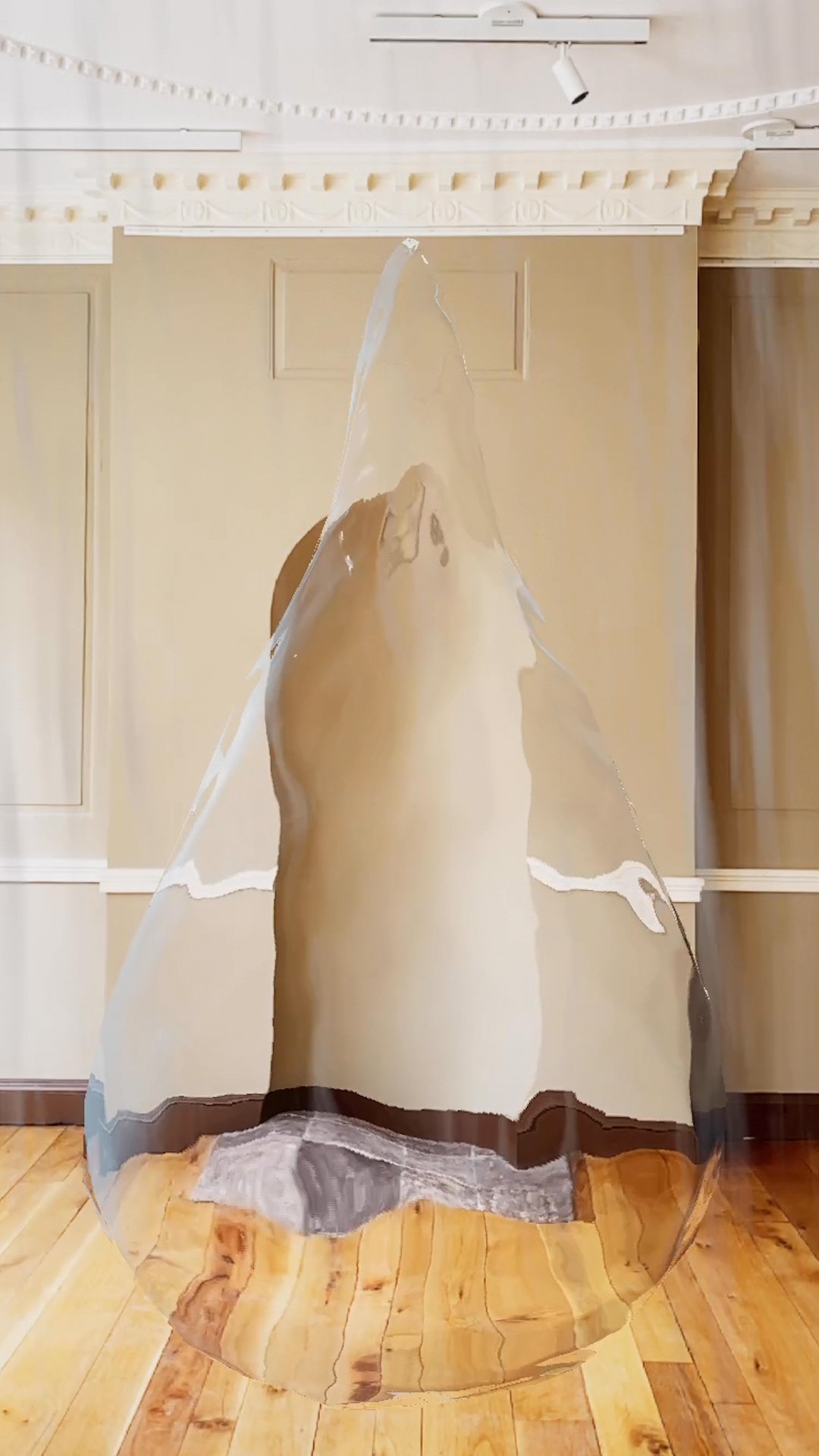 In an abstract image, the walls of a gallery are seen through a large drop of ice