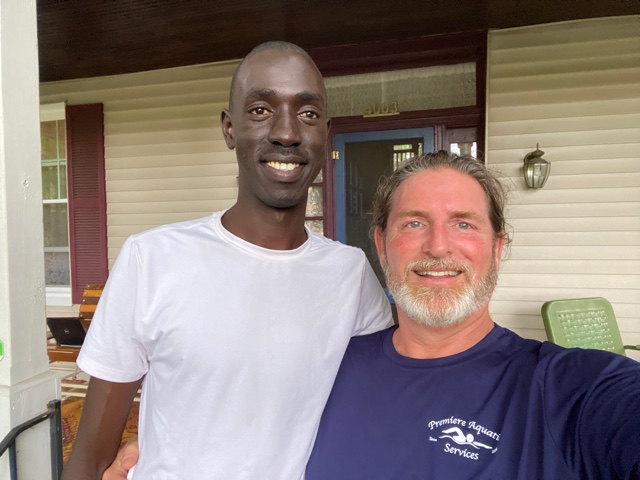 Male student and man smiling for selfie outside