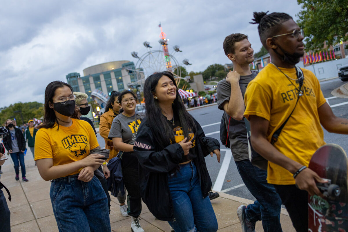 Students in UMBC gear walk away from the carnival