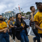 Students in UMBC gear walk away from the carnival