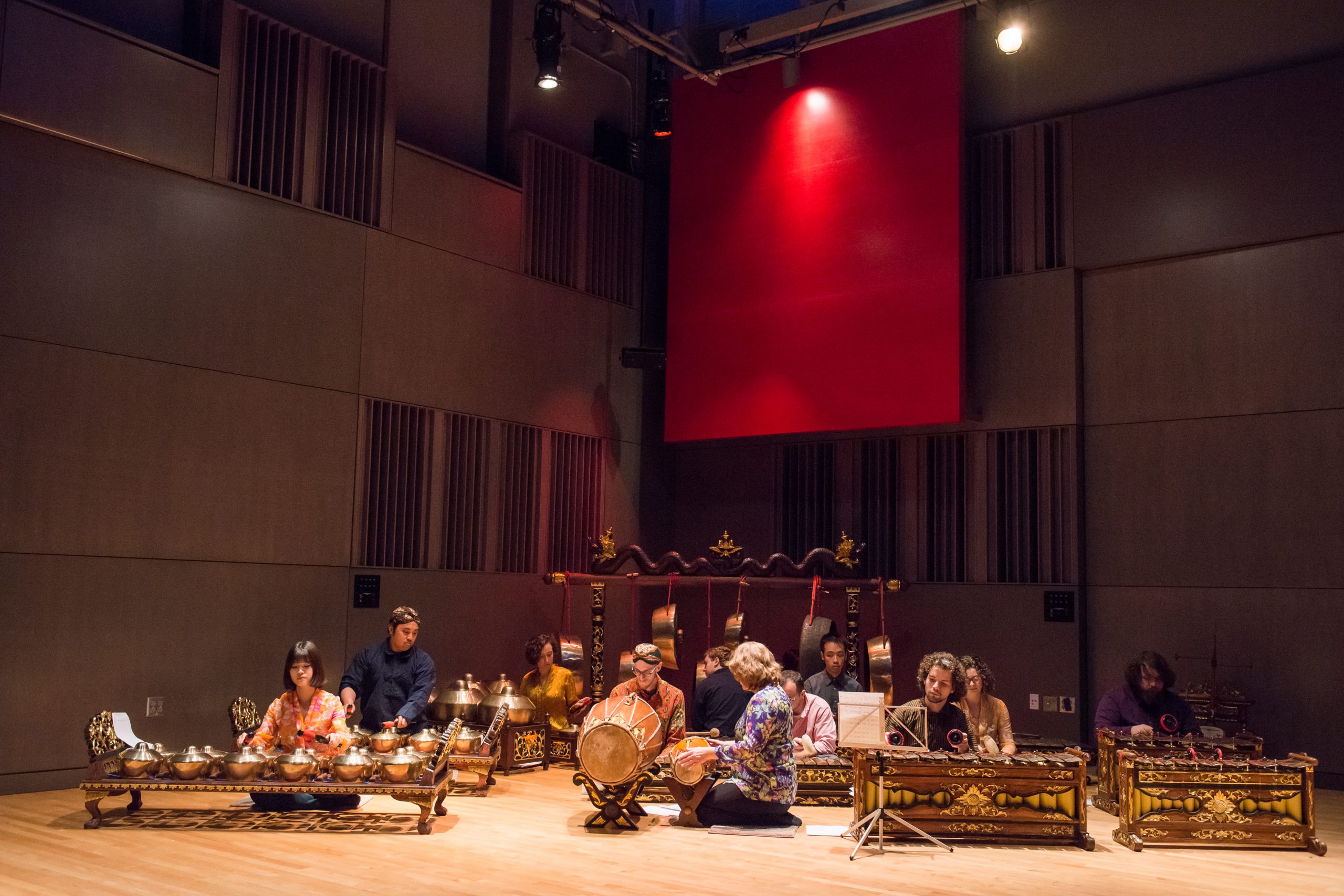 An ensemble of seated musicians performs on a gemelan