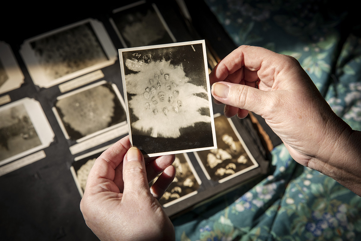 Two hands hold a old black and white photograph.