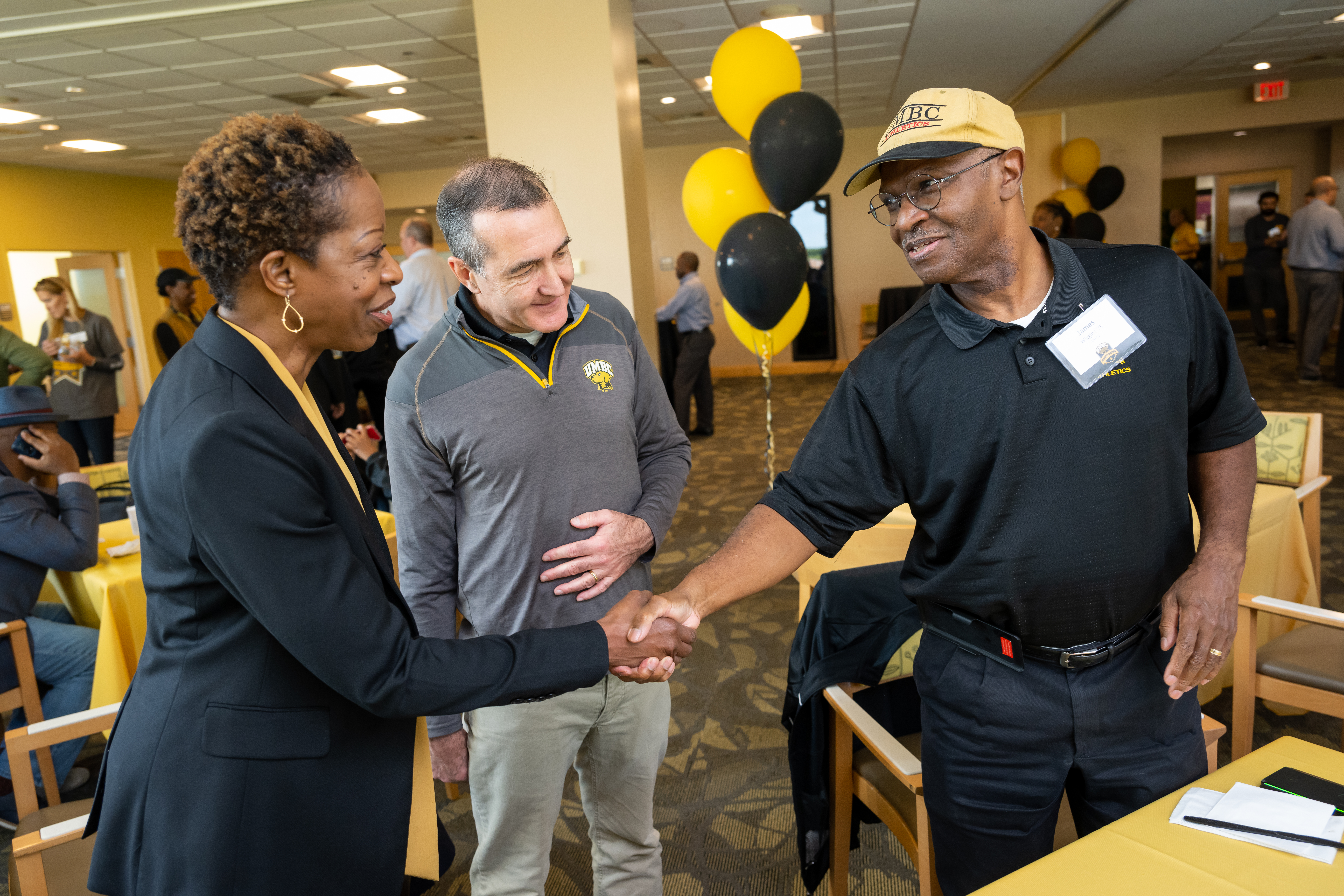 Dr. Sheares Ashby shakes hand with an alumnus.