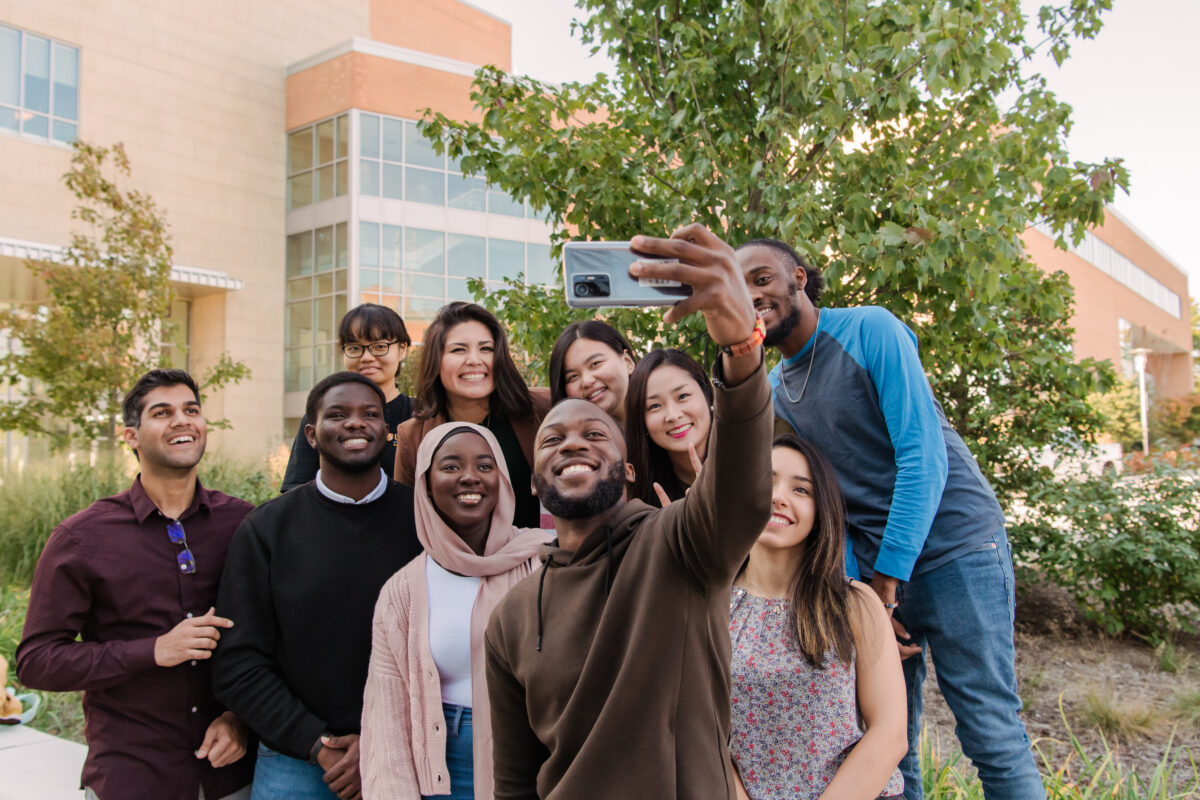 A group of people gather together for a selfie.