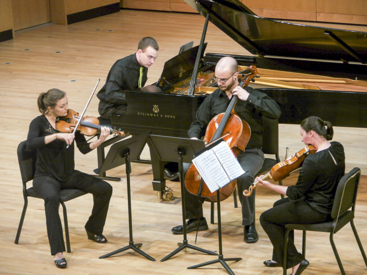 A group of four musicians perform on stage