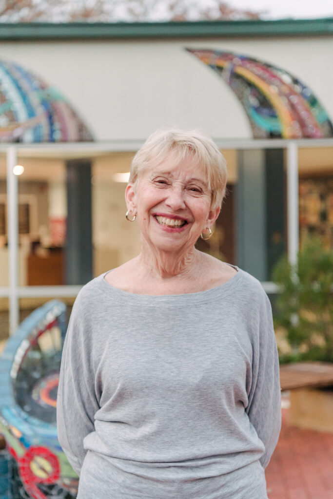 Headshot of an older lady in front of a colorful background