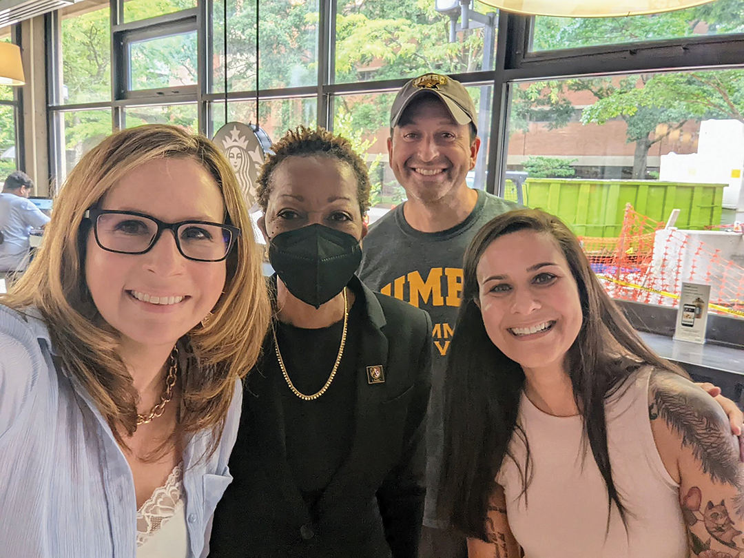 UMBC Staff smile for a selfie with the UMBC President.