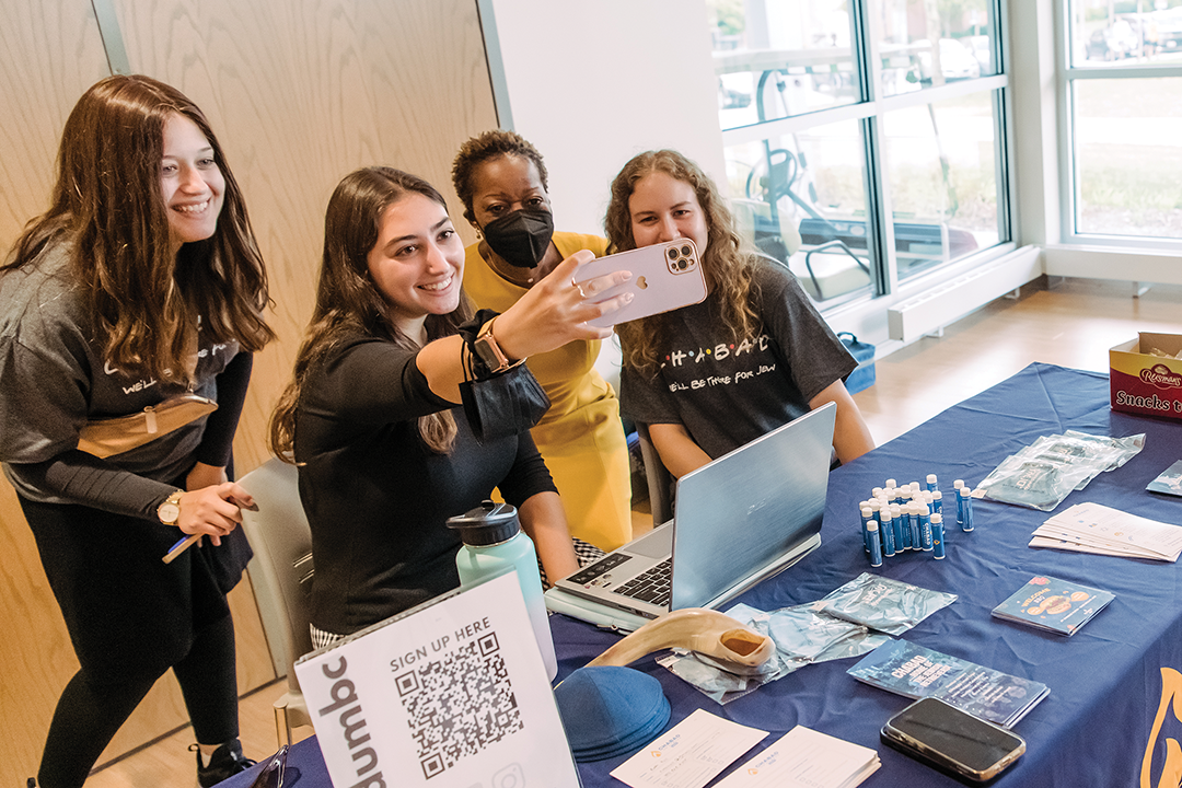 President of UMBC poses for a selfie with members of the student organization Chabad.