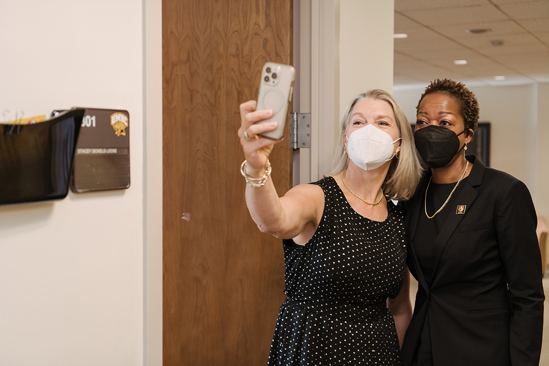 Two women pose for a selfie in the administration building