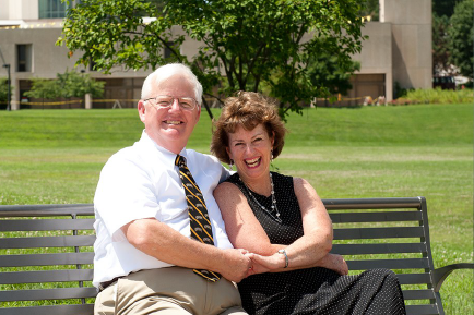 Image of two senior-aged adults sitting on a bench together.