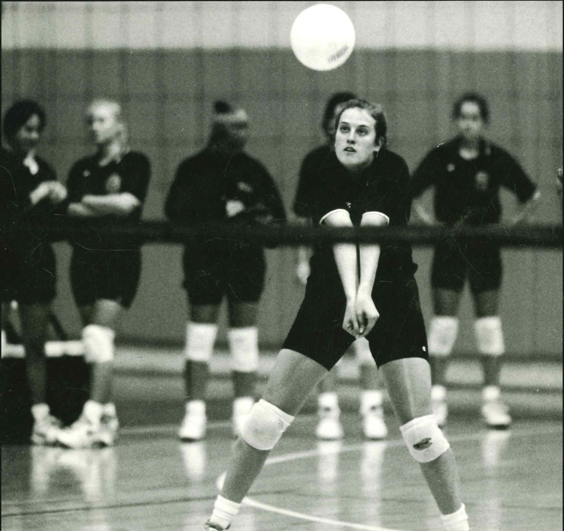 A volleyball player prepares to hit a ball back over the net