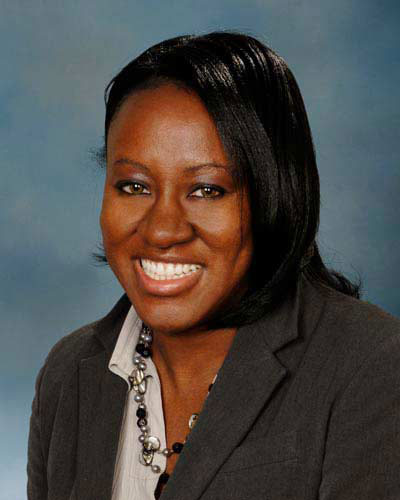 Professional headshot of a smiling woman in a suit jacket