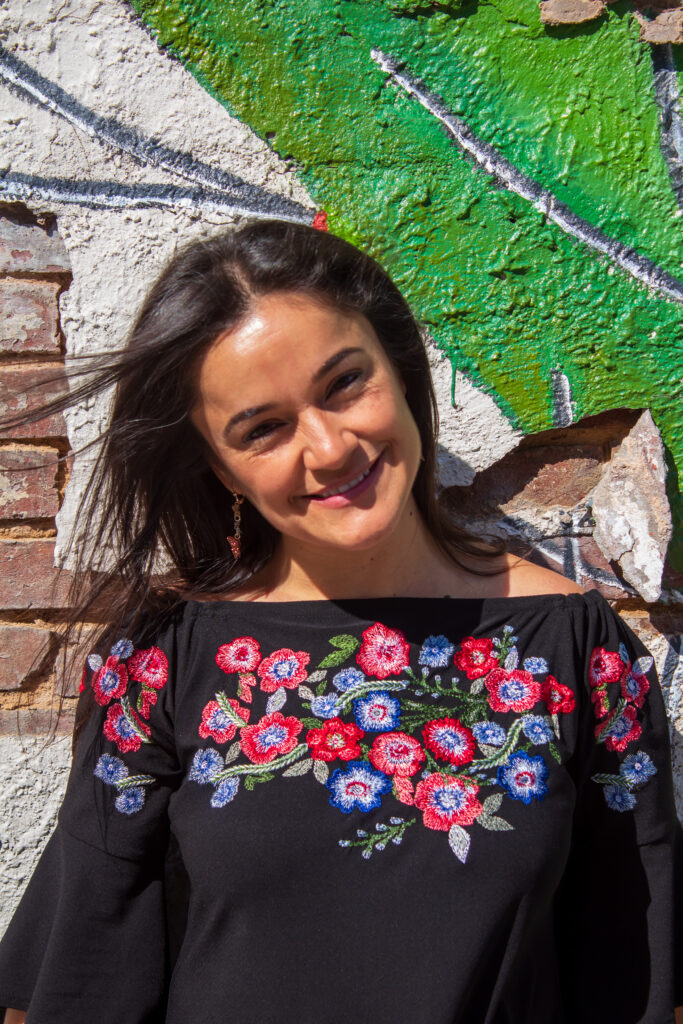 Headshot of a smiling woman in a floral blouse