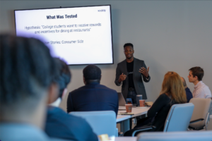 A young entrepreneurial speaker presents in front of a projection