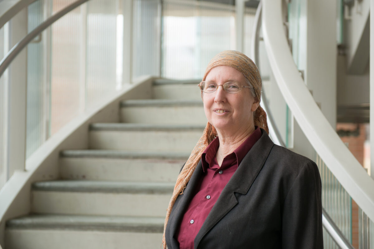 Lorraine Remer, one of UMBC's most-cited scientists -- a woman with glasses who is smiling while standing near a staircase.