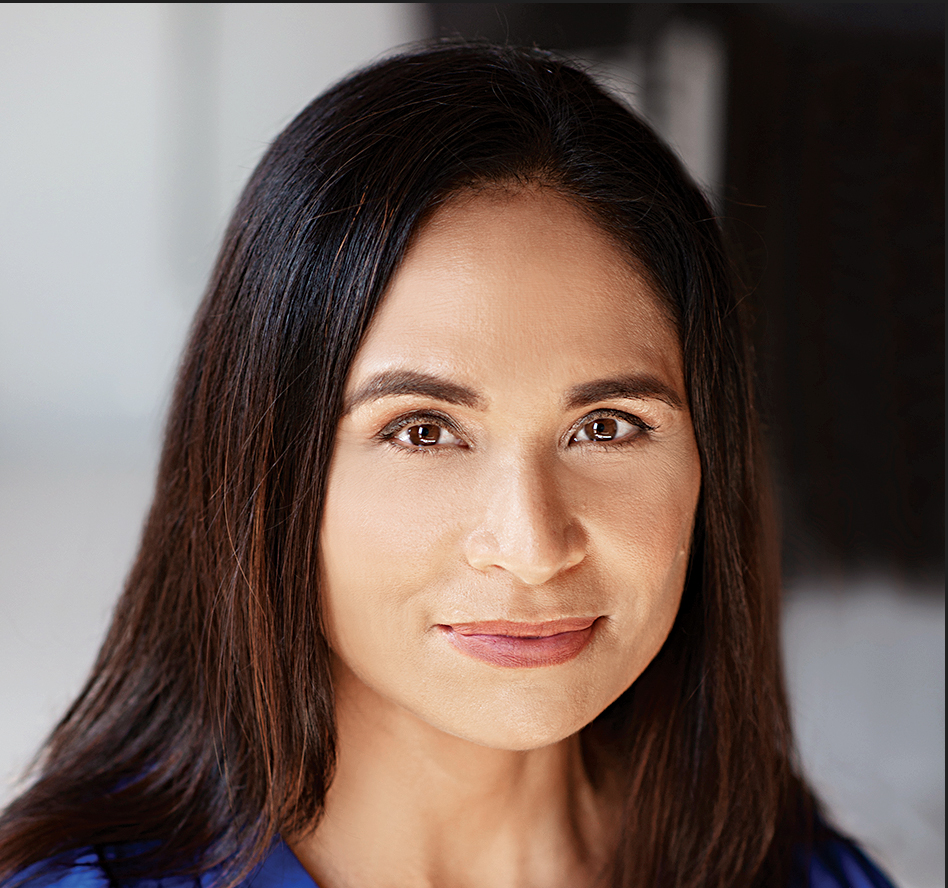 An brown-skinned Asian woman with long, dark hair is looking toward the camera.