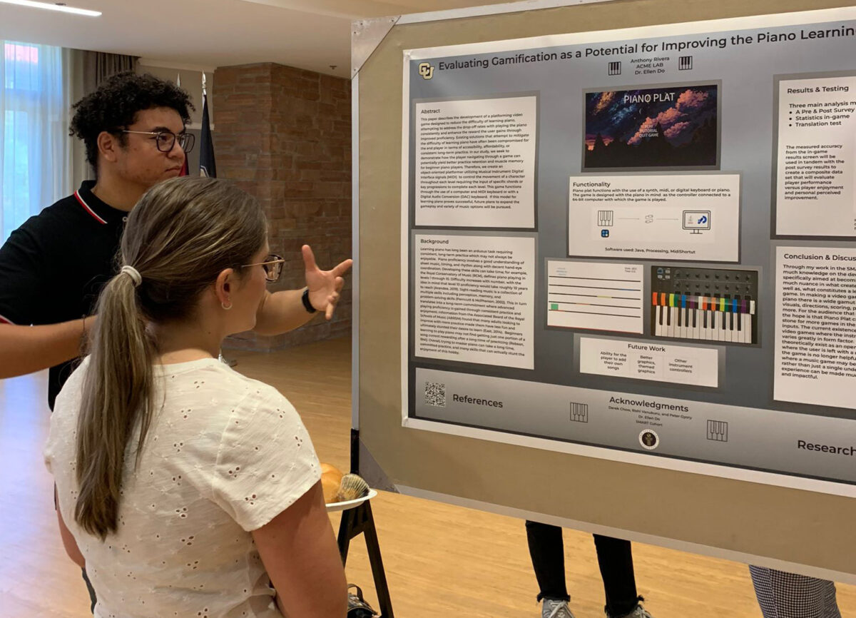 Information systems student Anthony Rivera explains his research to another researcher