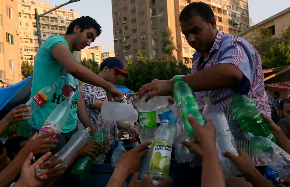 People hand over plastic bottles to be refilled with water