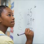 A girl writes arithmetic equations on a whiteboard
