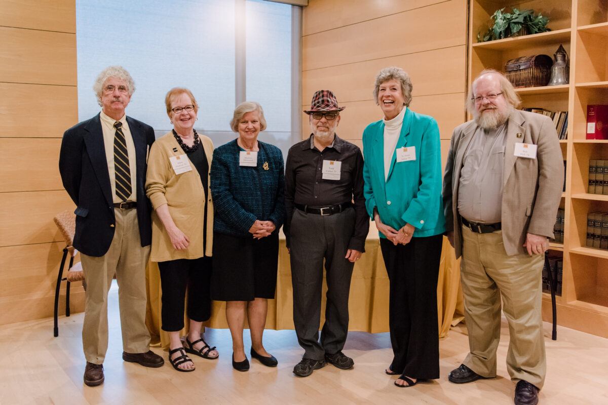 Six people stand in a row in a nice room.