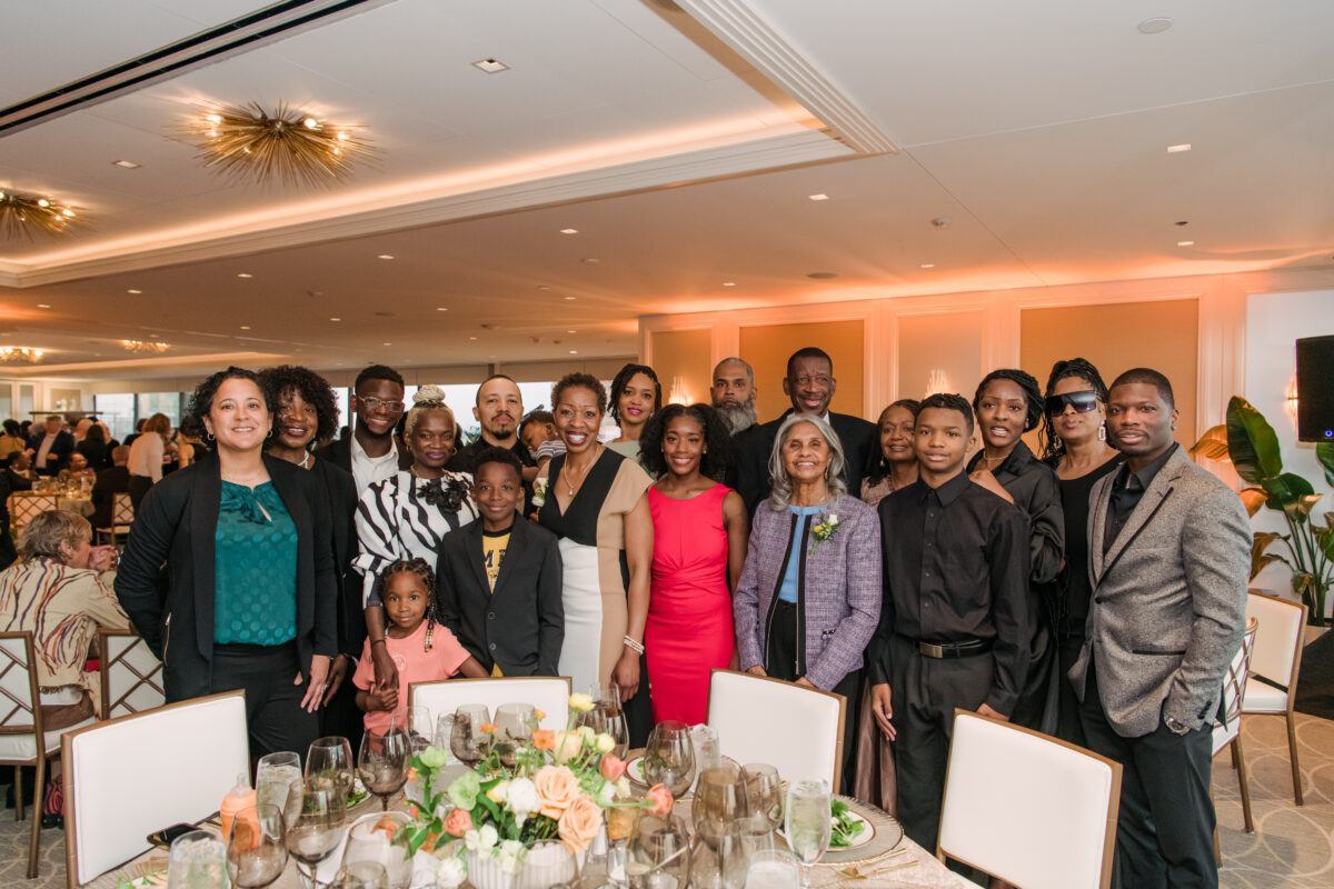 A family poses together in front of a table in a formal dinner setting