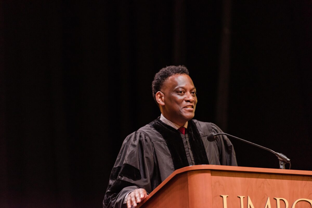 Keith Elder speaks at Commencement from behind a podium that says UMBC